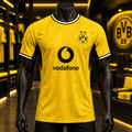 A yellow Borussia Dortmund soccer jersey with black and white trim, displayed on a black mannequin in a dimly lit store interior. The jersey features the black Vodafone logo and the BVB 09 crest on the chest.