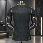 Black Nike athletic short-sleeve shirt shown from the back on a black mannequin, with bright yellow-green contrast stitching and logo details, set against a dark gym-themed background.