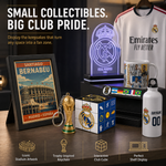 A Real Madrid themed merchandise display featuring a framed Bernabeu stadium poster, a trophy keychain, an interactive cube, a glowing acrylic plaque, a mug, a white bottle, and a Real Madrid jersey on a shelf, with promotional text at the top and feature icons at the bottom.