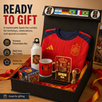 A Spain football-themed gift set displayed inside an open black presentation box. The set includes a red and navy Spain jersey, a white water bottle with a crest, a red mug, a small trophy replica, a plaque, a box of stickers, and a framed photo, with promotional text reading 'READY TO GIFT'.