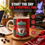 A red Liverpool Football Club ceramic mug sits on a wooden desk with coffee beans, a notebook, and a laptop nearby. Large promotional text at the top reads 'START THE DAY LIKE A FOOTBALL FAN' with feature callouts on the right, and a glowing Liverpool neon sign is visible in the background.