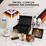 Germany soccer fan experience gift set in one box, featuring a white Germany jersey, presentation box, water bottles, mug, LED lamp, keychain, cube, and framed print on a clean white background with labeled callouts.