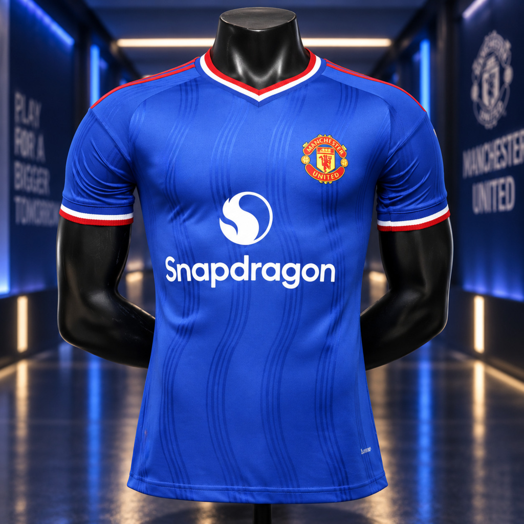 A blue Manchester United soccer jersey displayed on a black mannequin torso in a futuristic blue-lit corridor. The jersey features the Manchester United crest on the left chest, a white Snapdragon logo in the center, and red and white trim on the collar and sleeve cuffs.