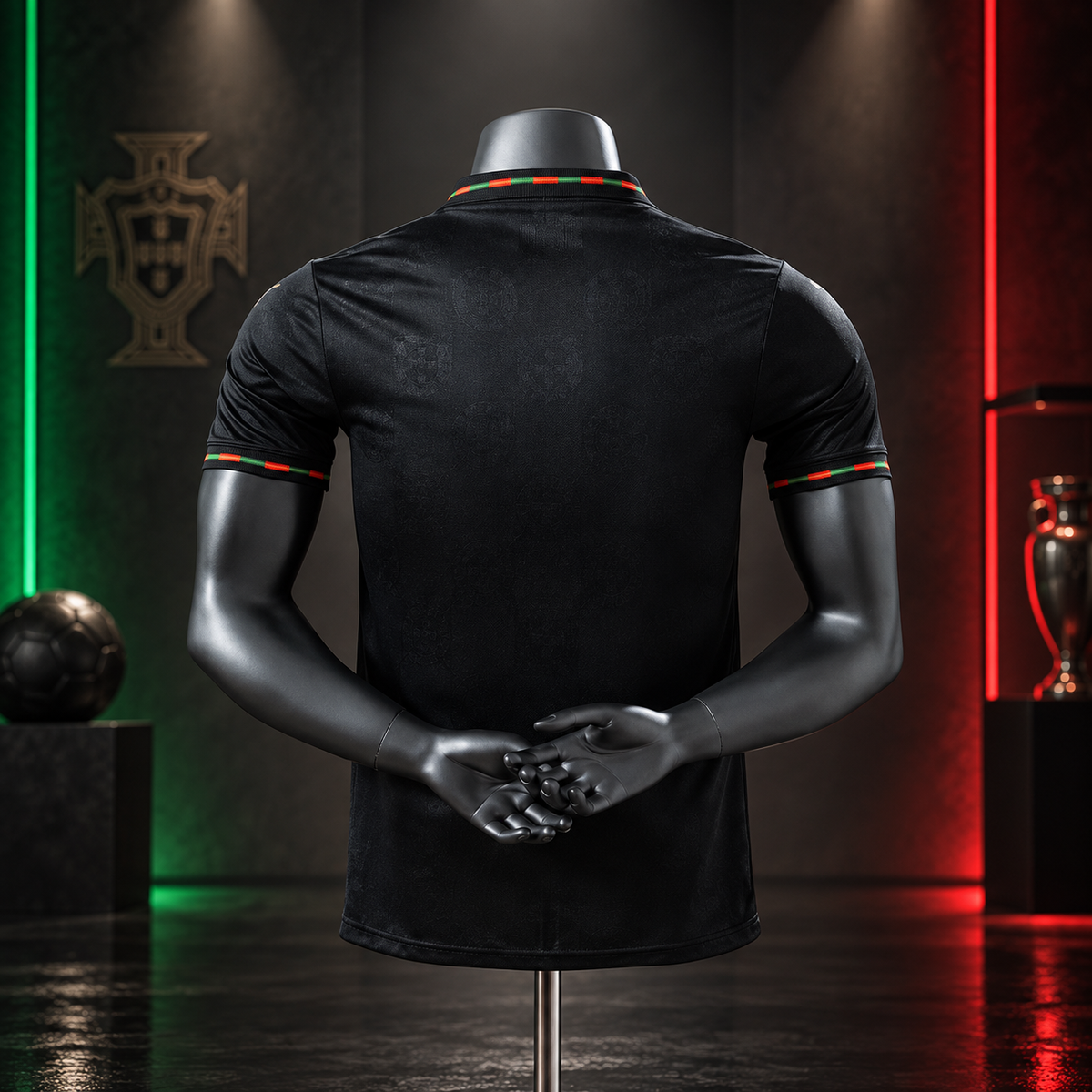 Black short-sleeve polo shirt shown from the back on a dark mannequin, with red and green striped collar and sleeve trim. The shirt is photographed in a dramatic studio setting with green and red lighting, a Portugal crest on the wall, and sports trophies in the background.
