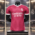 A Real Madrid soccer jersey in dark pink with white accents, displayed on a black mannequin torso. The jersey features the white 'Emirates FLY BETTER' sponsor logo on the chest and the Real Madrid crest on the left chest.