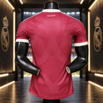 A dark pink Real Madrid soccer jersey shown from the back on a black mannequin torso, with white trim on the collar and sleeve cuffs, and the 'RMCF' logo printed at the neck.