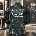 A Paris Saint-Germain soccer jersey displayed on a black mannequin torso inside a retail store. The jersey features a dark green and black marbled pattern with white printed logos for Jordan, Qatar Airways, and Paris Saint-Germain.